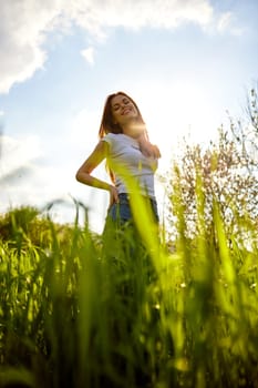 bright, happy woman posing while standing in tall grass. High quality photo