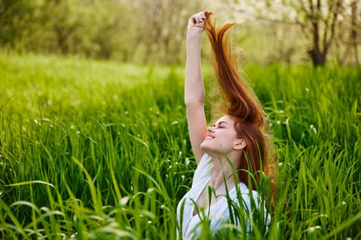 a red-haired woman stands in the tall grass, raising her oxen up and laughing widely with her teeth. High quality photo