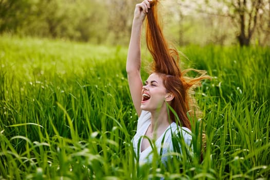 a red-haired woman stands in the tall grass, raising her oxen up and laughing widely with her teeth. High quality photo