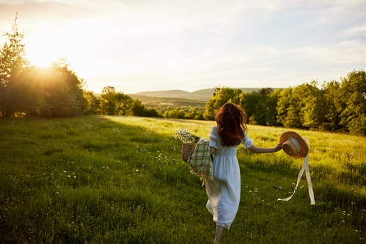 a woman in a light dress stands in a field during sunset with a wicker basket, a hat and a plaid in her hands. High quality photo