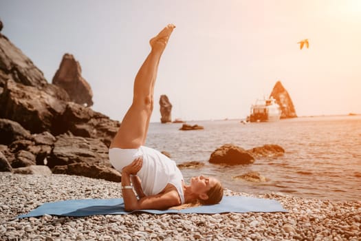 Woman sea yoga. Back view of free calm happy satisfied woman with long hair standing on top rock with yoga position against of sky by the sea. Healthy lifestyle outdoors in nature, fitness concept.