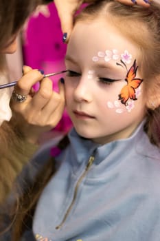 childrens makeup face paint drawings Girls face painting 23.02.2022 . Kyiv, Ukraine. Little girl having face painted on birthday party. High quality photo