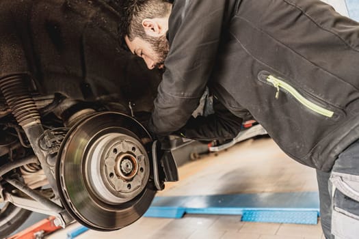 Skilled mechanic expertly replaces brake pads on a car with precision and care.