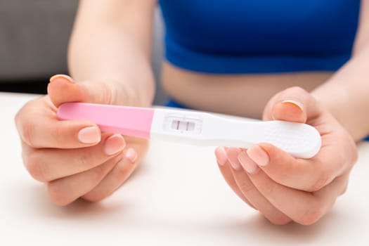 Close up woman holding a positive pregnancy test