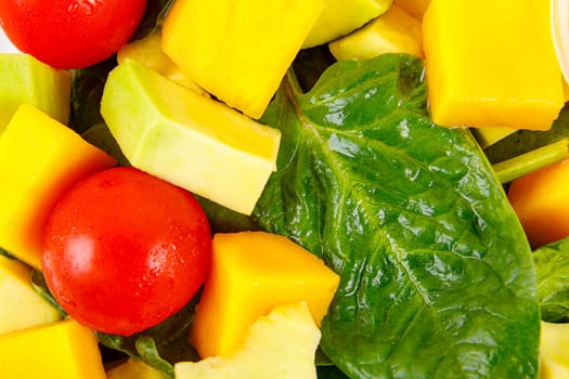 Fresh salad of avocado, mango, spinach and cherry tomatoes, close-up. High quality photo
