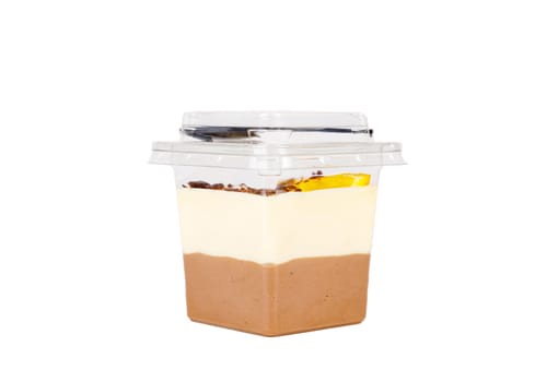 Dessert of white and brown cream with an orange slice in a plastic container on a white background