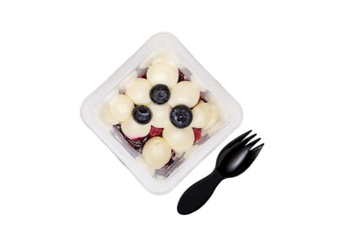Dessert of cream, jam and blueberries in a plastic glass on a white background. High quality photo