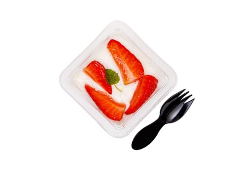Dessert of white and pink cream with strawberries in a plastic container on a white background. High quality photo