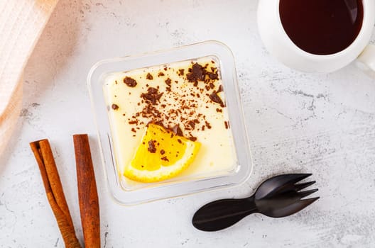 Tiramisu dessert in a plastic box with a fork on a concrete background. High quality photo