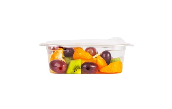 Fruit salad of pineapple, orange, kiwi and grapes in a plastic container on a white background. High quality photo