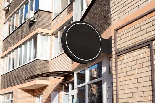 Black round logo on brick wall, building exterior for mockup design