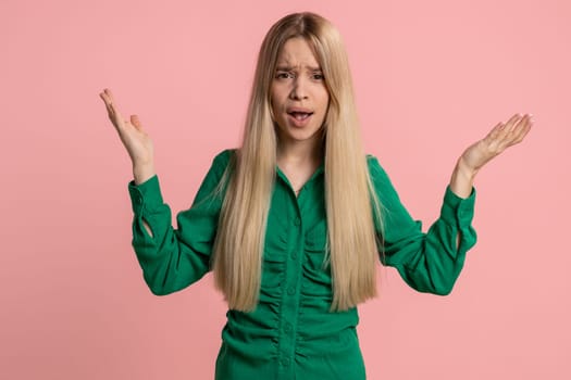 What. Why. Sincere irritated caucasian woman raising hands in indignant expression asking reason of failure demonstrating disbelief irritation by trouble. Pretty confused girl on pink wall background