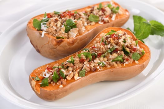 Baked stuffed pumpkin filled with walnuts, fresh mint and chili with quinoa tabbouleh. The maple syrup makes them excellent. It is a healthy side dish or main dish for vegans and paleo.