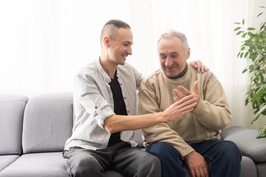 Help needed. Pleasant senior man sitting on the sofa.