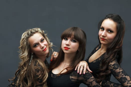 Portrait of three attractive sexy dancers posing in studio