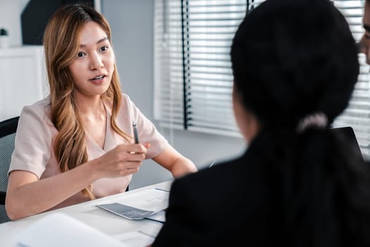 A young female asian candidate tries to impress her interviewer by being competent. International company, multicultural environment in workplace.