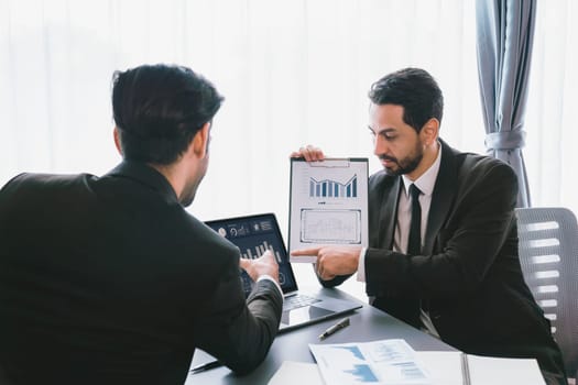 Busy analyst team discussing financial data on digital dashboard, analyzing chart and graph using data science software display on a laptop screen. Business intelligence and Fintech. Fervent