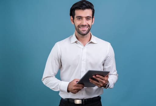 Confident businessman in formal suit holding tablet with surprise look for promotion or advertising. Facial expression and gestures indicate excitement and amazement on an isolated background. Fervent