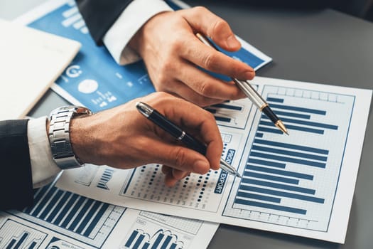 Closeup busy analyst team discussing financial data on digital dashboard, analyzing chart and graph using data science software display on a laptop screen. Business intelligence and Fintech. Fervent