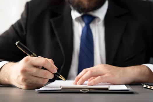 Businessman signs contract agreement paper or business legal form with trust and professionalism. Closeup of hand holding pen in corporate meeting for official business deal. Equilibrium