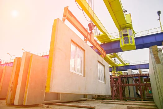 A builder installs a concrete floor slab panel at a construction site. Installation of a concrete floor slab for a multi-storey building.