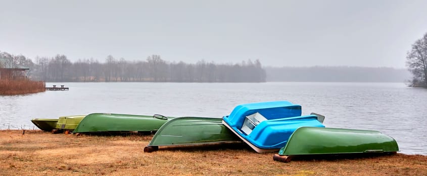 Old boats are overturned on the shore. Boat station. The boats are dry. Water transport.