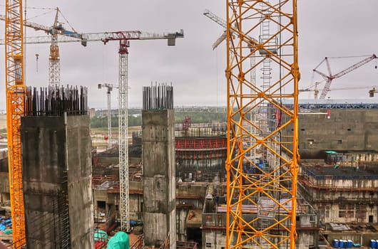 Construction of a nuclear power plant. Tower cranes on the background of the cooling tower.