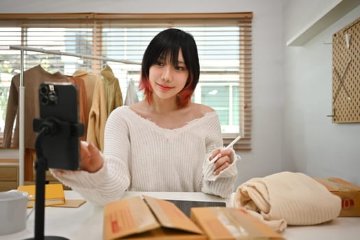Young asian female small business owner in casual clothes and checking customer address or orders in an online store.