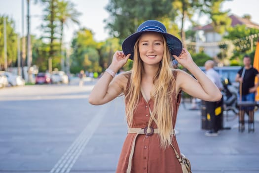 Happy woman tourist on background of old street of Antalya. female tourist traveler discover interesting places and popular attractions and walks in the old city Kalechi of Antalya, Turkey. Turkiye.