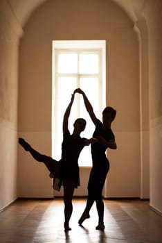 Silhouette of pair of two dancers in corridor of theatre