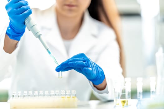 conducting chemical research in a research laboratory. pipetting the sample into glass flasks.