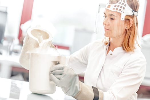 research with liquid nitrogen in the laboratory is carried out by a young female scientist.