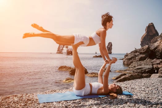 Woman sea yoga. Back view of free calm happy satisfied woman with long hair standing on top rock with yoga position against of sky by the sea. Healthy lifestyle outdoors in nature, fitness concept.