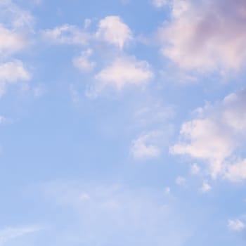 Background of blue sky with pale pink clouds at sunset