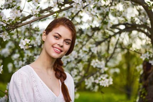 Beautiful young woman. model in white dress stands in white flowers. Horizontal photo. copy space.High quality photo