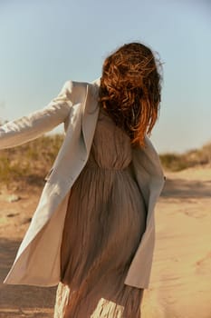 stylish woman with long red hair covering her face posing in nature. High quality photo