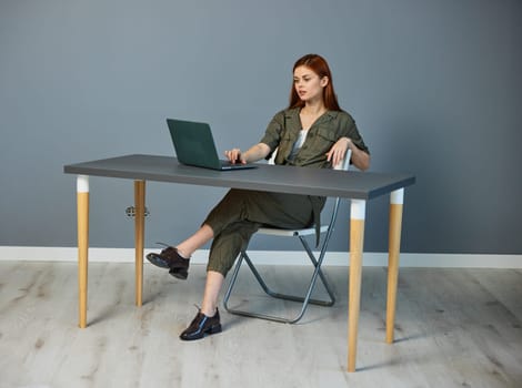 serious businesswoman working on a laptop while sitting at a table in the office. High quality photo