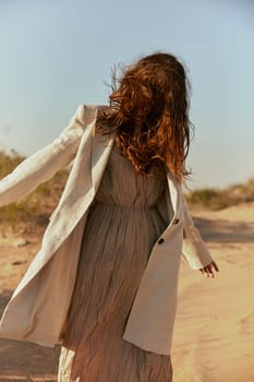 stylish woman with long red hair covering her face posing in nature. High quality photo