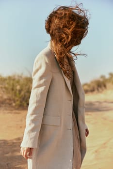 a strong wind inflates a woman with red, long hair. High quality photo