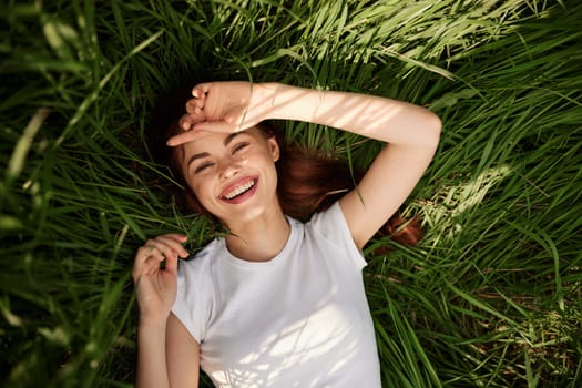 portrait of smiling happy woman with teeth on the grass. High quality photo