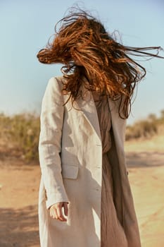 custom portrait of a woman in a light coat with red hair covering her face. High quality photo