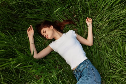 woman lies in tall grass falling asleep in nature. High quality photo