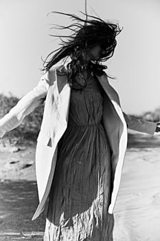 monochrome photo of a woman in a jacket against a clear sky on the coast. High quality photo