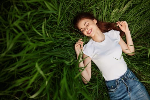 tender, beautiful woman resting lying in the grass in sunny weather. High quality photo