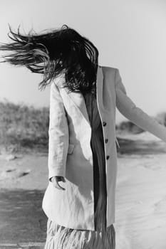 monochrome photo of a woman in a jacket against a clear sky on the coast. High quality photo