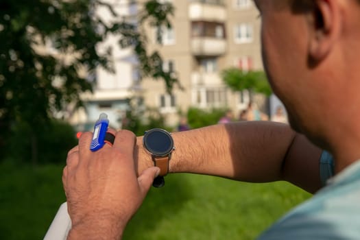 An athlete participating in orienteering competitions sets up a smartwatch before the start. Smart watches have become an essential accessory for athletes.