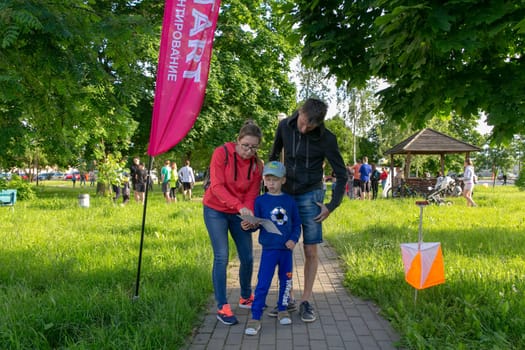 Grodno, Belarus - 15 June, 2022: Training of the Veras orienteering club . A young family of three people at the start of the route check the map and choose the direction to move.