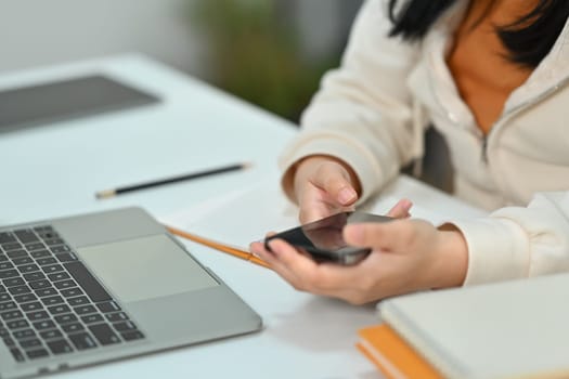 Young woman hand texting text message on mobile phone. Communication, technology and lifestyle concept.