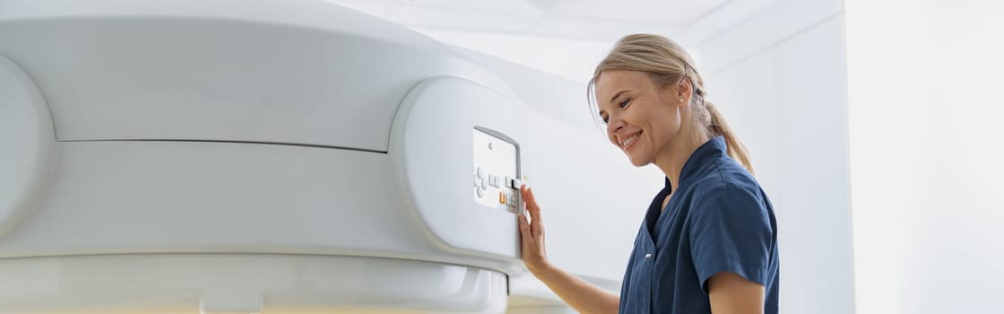 Radiologist controls MRI or CT Scan with patient undergoing procedure. High Tech medical equipment