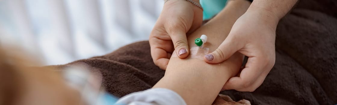 Nurse putting a drip in the arm of her patient in modern medical clinic. High quality photo